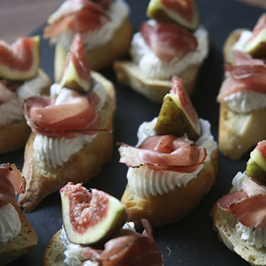 Crostini served with goat cheese, fresh figs and Prosciutto