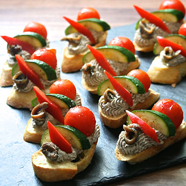 Crostini of tapenade, roasted cheery tomato, courgette and grilled red pepper